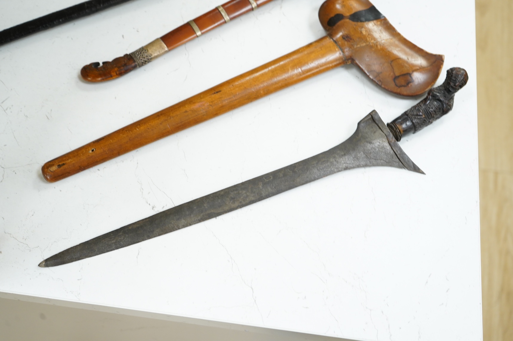 A Javanese dagger kris with straight pamor blade, wooden hilt carved as raksha, in its wooden sheath, together with a decorative dagger bade-bade, with etched blade